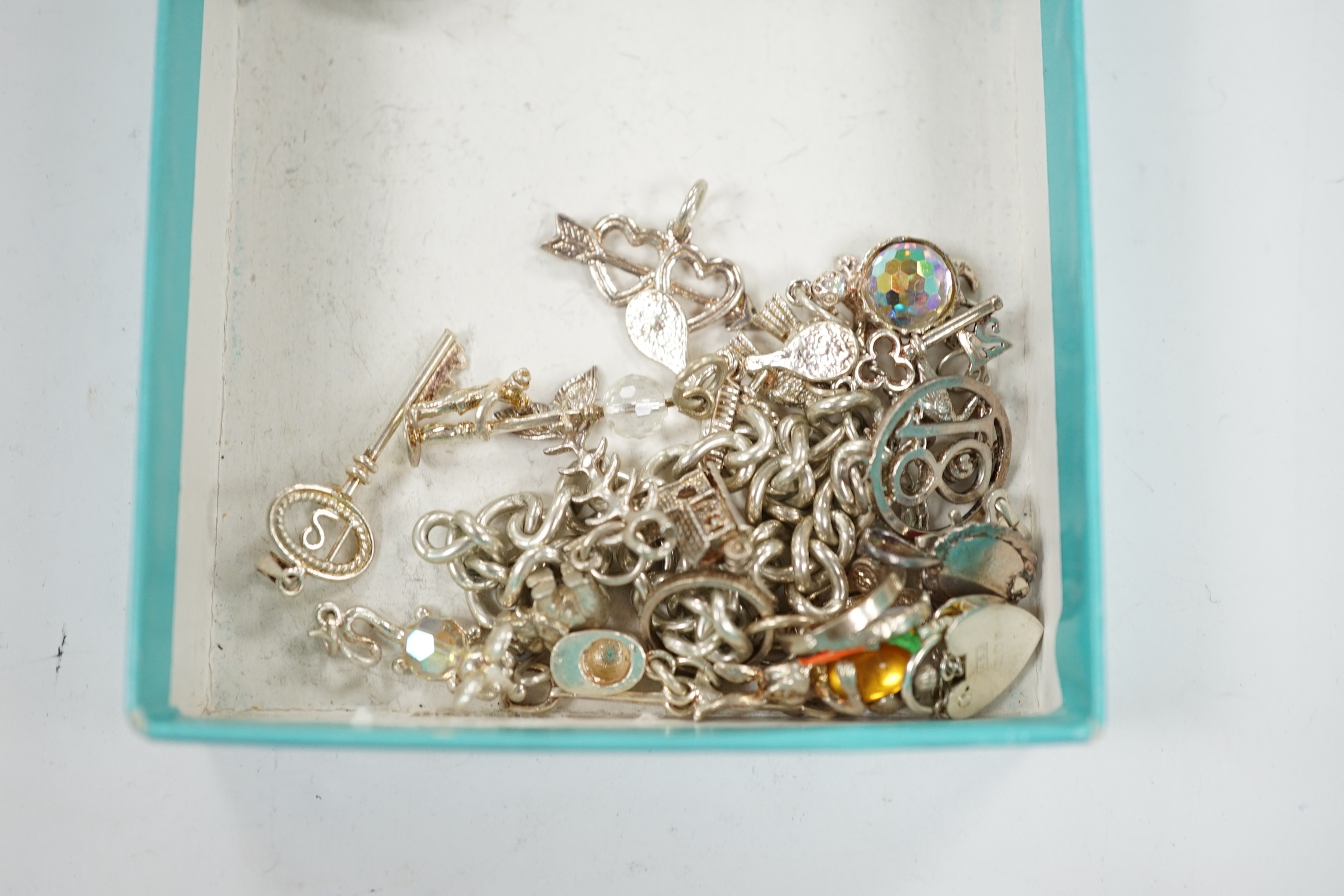 A 1970's silver charm bracelet, hung with assorted charms including birdcage, abacus, piglet, etc. and another silver charm bracelet with loose charms.